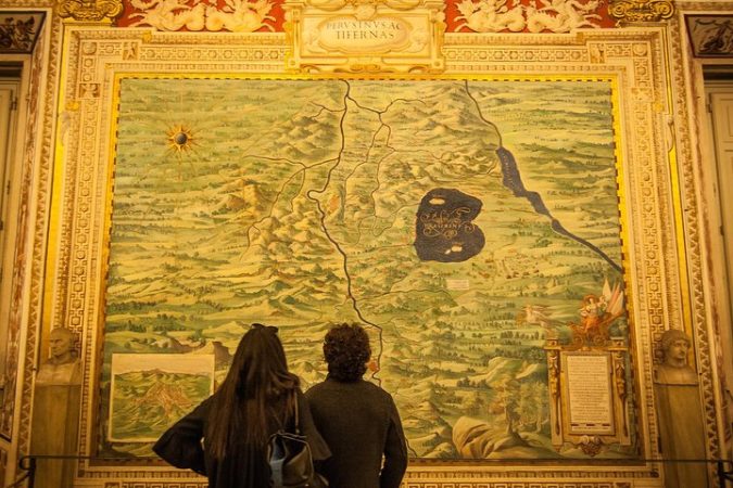 Travelers in gallery of the maps in the Vatican Museums in Rome, Italy